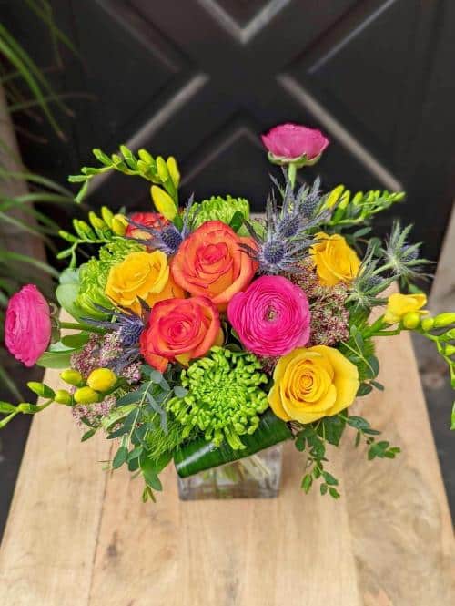 The Watering Can | A compact and colourful hand-tied bouquet set in a square glass vase.