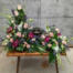 The Watering Can | A spectacular blush, plum and blue creamtion design. Soraing above the urn on the right, the arrangement flows around the urn, forwads and down again on the left.