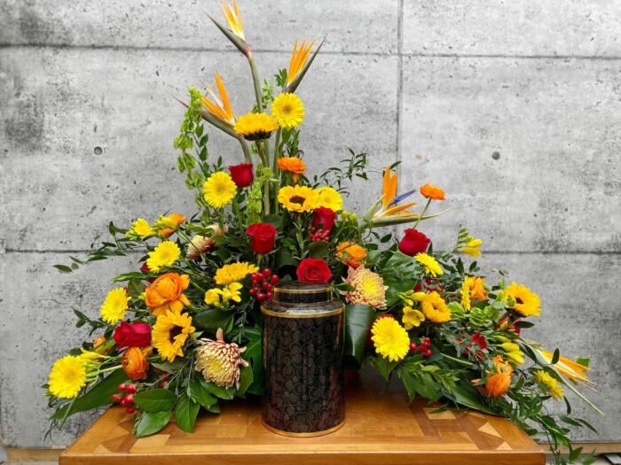 The Watering Can | A bright and warm, tropical cremation display in reds, yellows, and oranges.