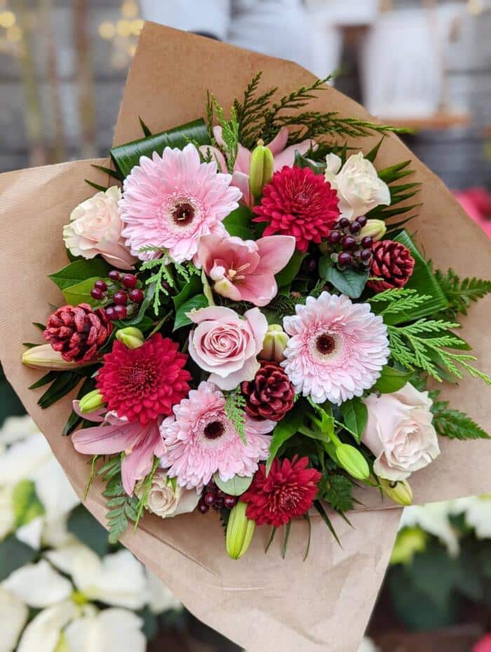 The Watering Can | A pink and burgundy bouquet made with cedar and pinecones amongst the flowers.