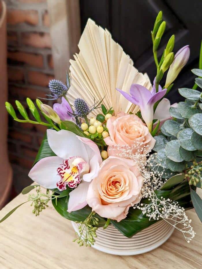 The Watering Can | Alternate view of a pastel coloured European style arrangement with fresh and dried flowers.