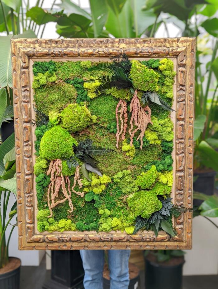 The Watering Can | A large piece of moss art in varying shades of green presented in a carved wooden frame.