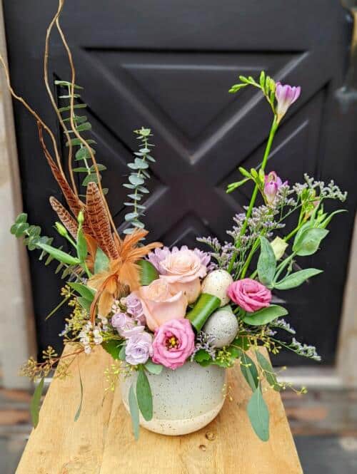 The Watering Can | An european style floral arrangement designed with pink florals, feathers and an egg to decorate.