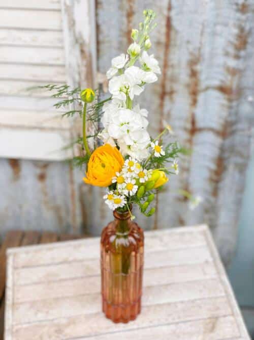 The Watering Can | Yellow and white blooms in a tall yellow bud vase.