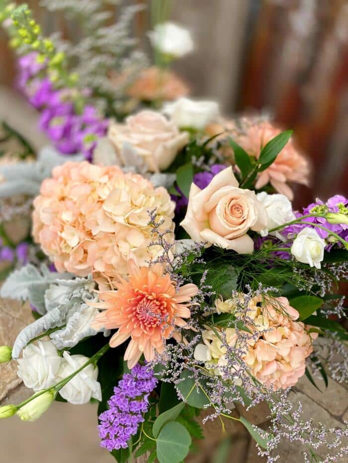 The Watering Can | Blush and purple flowers in a garden style bouquet.