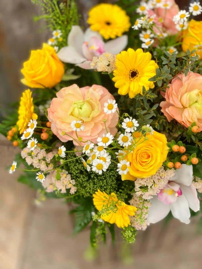 The Watering Can | Yellow and blush flowers in a bouquet and vase arrangement.