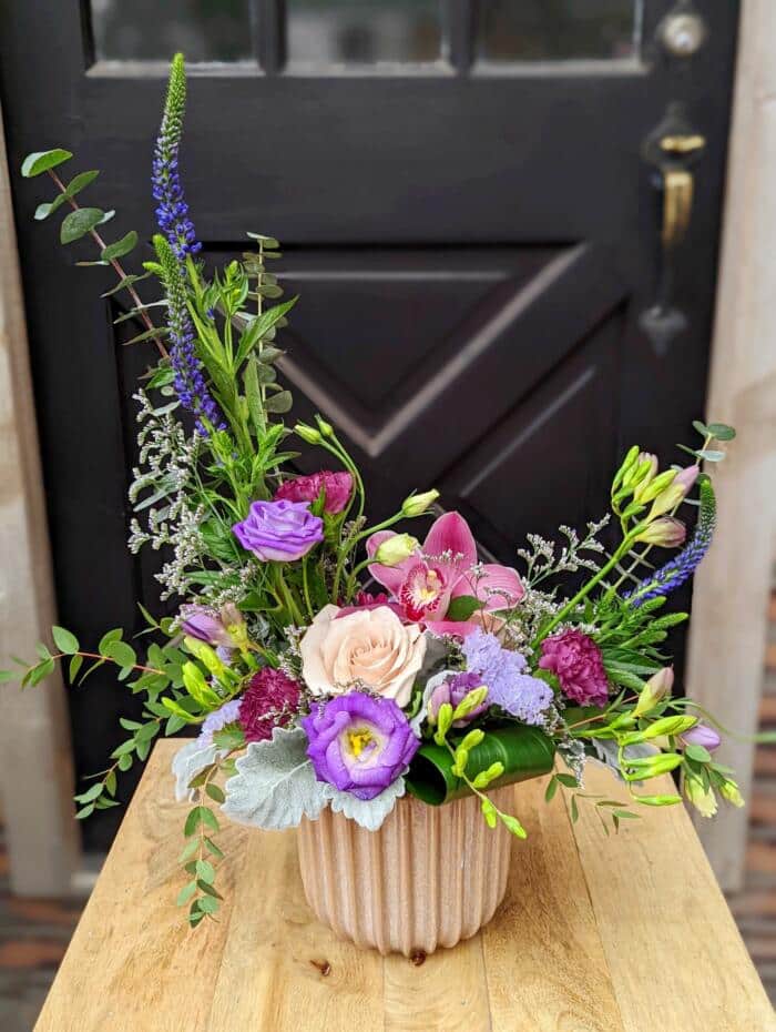 The Watering Can | A European style arrangement in pink and purple blooms.