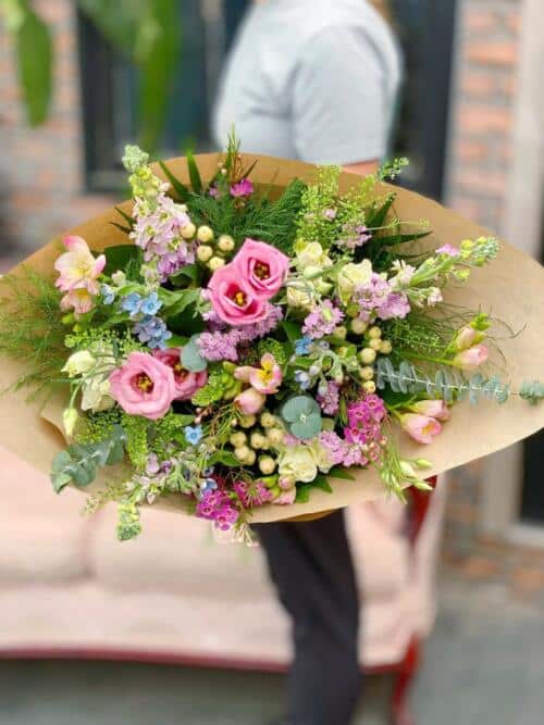 The Watering Can | A pink hand-tied bouquet with lots of garden greenery.
