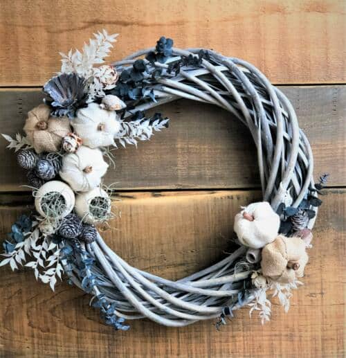 The Watering Can | This wreath is made on a grey washed woven wreath. You will decorate it with preserved eucalyptus, ruscus, bell cups, pumpkins, assorted pinecones and mosses