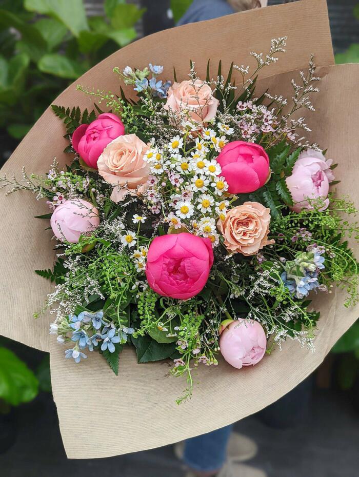 The Watering Can | A bouquet featuring pink peonies with some roses and garden flowers and foliage.