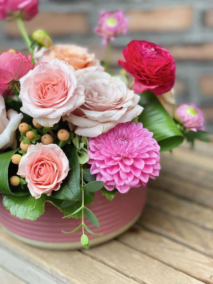 The Watering Can | Pink dahlia, soft pink roses,, and hot pink ranunculus in an European style floral arrangement.