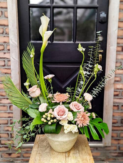 The Watering Can | A peach and white Euopean style arrangement with height in a white ceramic container.