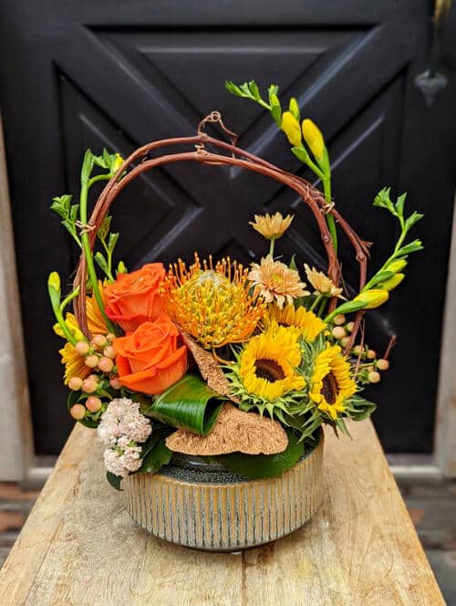 The Watering Can | A yellow and orange European style floral arrangement.