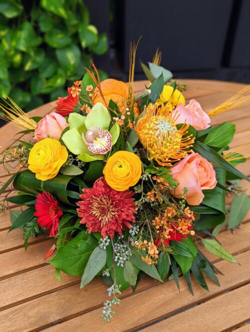 The Watering Can | A citrus coloured table centerpiece with dired wheat accents.