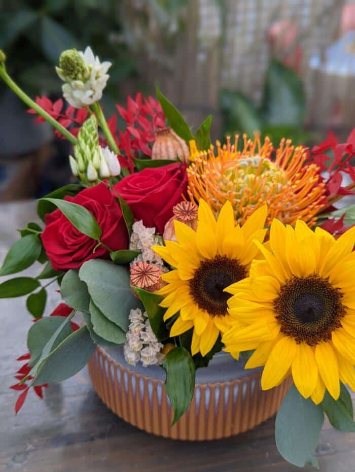 The Watering Can | Sunflowers in an European style floral arrangement.