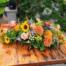 The Watering Can | An oblong fall themed table centerpiece with yellow, orange, and burgundy.