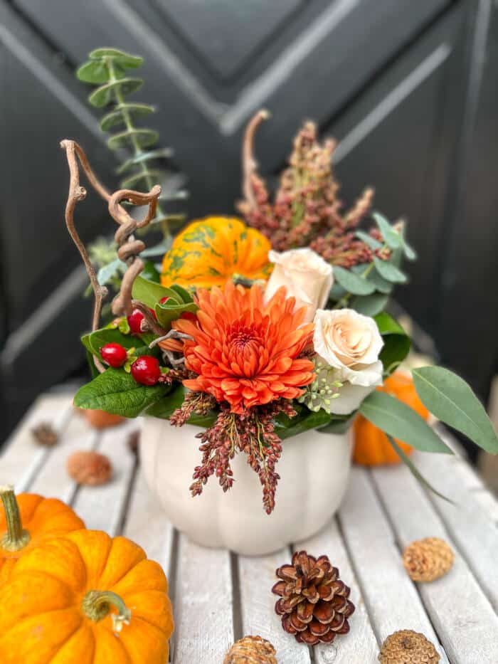 The Watering Can | A fall European style arrangement in a white pumpkin shaped container.
