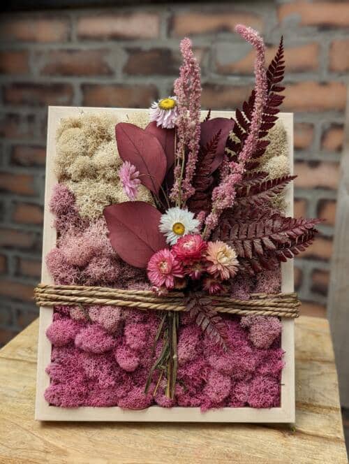 The Watering Can | An all pink moss frame with a gradient of mosses with a small bouquet of pink dried florals adding embellishment.