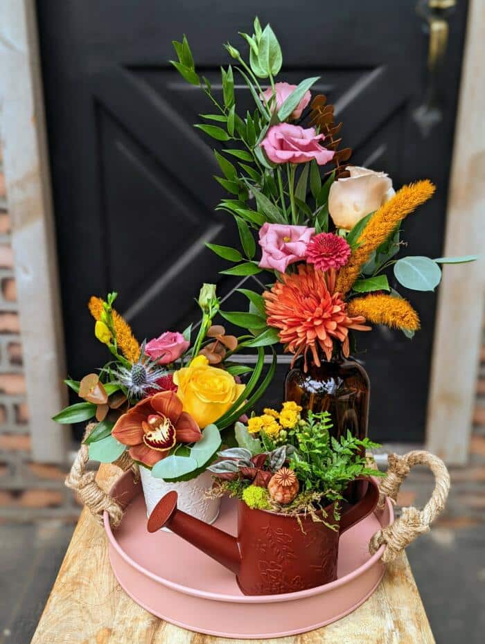 The Watering Can | A small collection of flowers on a tray. Includes a small bouquet, small european style design, and a small planter all in fall colours.