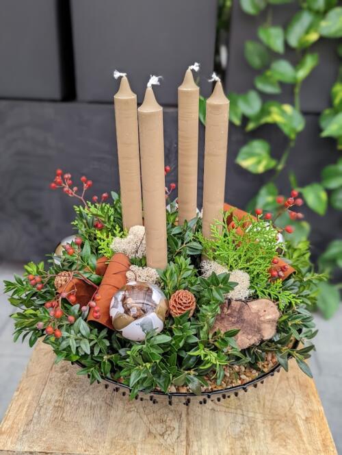 The Watering Can | Four beige candles in a festive arrangement designed in a low glass bowl.