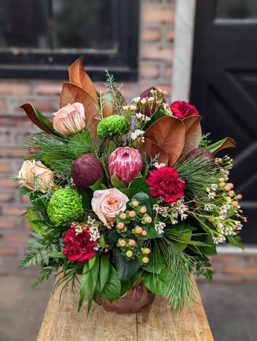 The Watering Can | A red green and blush winter bouquet in a vase.