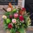 The Watering Can | A red green and blush winter bouquet in a vase.