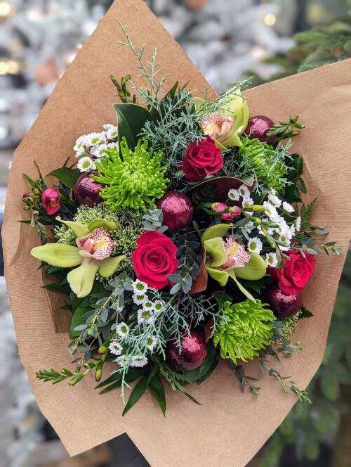 The Watering Can | A red, green, and burgundy hand-tied bouquet.