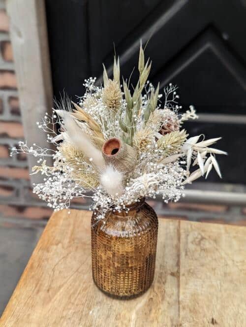 The Watering Can | A small bouquet of natural dried florals in a small brown glass vase.