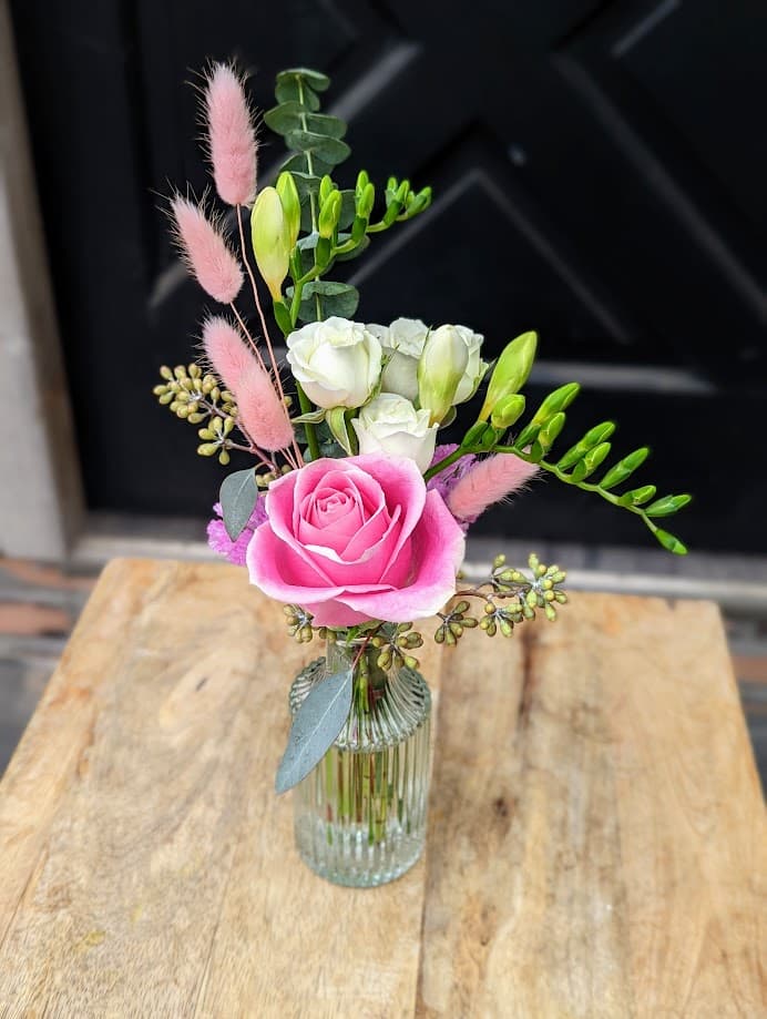 The Watering Can | A clear bud vase with pink and white flowers.