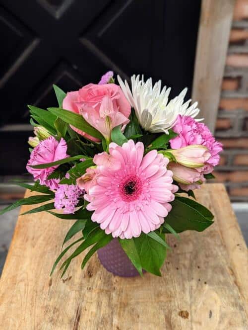 A small bouquet with large blooms in a glass vase. A variety of colours depending on your palette choice.