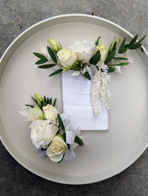 White pocket square boutonniere and wrist corsage. featuring white mini roses and lisianthus. Parvafolia eucalyptus.