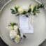 White pocket square boutonniere and wrist corsage. featuring white mini roses and lisianthus. Parvafolia eucalyptus.