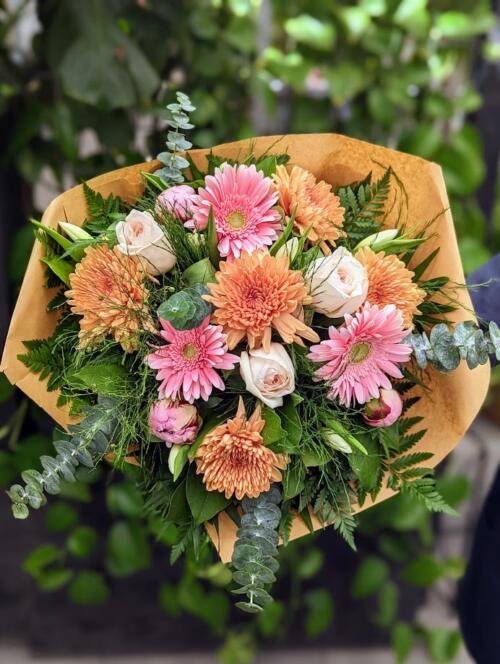 a bouquet overflowing with light pink and toffee blooms. toffee mums, light pink gerberas, baby blue eucalyptus, light pink roses and more.