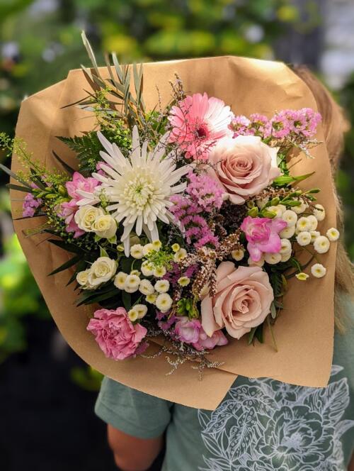 a pale pink and white wildflower bouquet featuring spray roses, mums, quicksand roses and so many more wildlwoer sprigs.