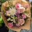 a pale pink and white wildflower bouquet featuring spray roses, mums, quicksand roses and so many more wildlwoer sprigs.