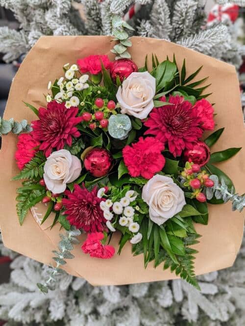 red white and green bouquet featuring white roses, red mums, red hypericum & carnations, eucalytpus and red ornaments