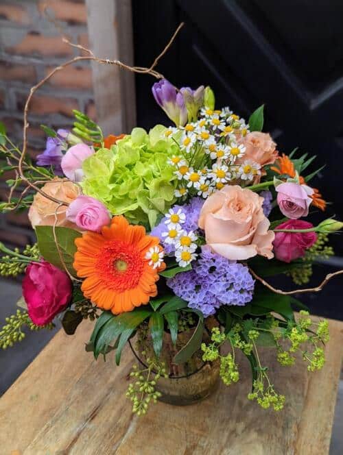 orange mini gerberas, purple statice, chamomile, hot pink lisianthus, green hydrangea, pink ranunculus