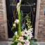a large asymmetrical european arrangement featuring large white calla llilies, blush roses, white orchid blooms and more.