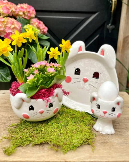 White ceramic bunny-shaped planter with pink kalanchoe and yellow daffodils