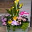 A second view of the Pink Lemonade arrangement from The Watering Can, showing the full composition of yellow calla lilies, pink blooms, and tropical foliage.