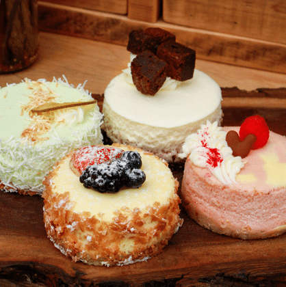 Display of beautifully decorated mini cakes at The Watering Can Pastry Market in Vineland