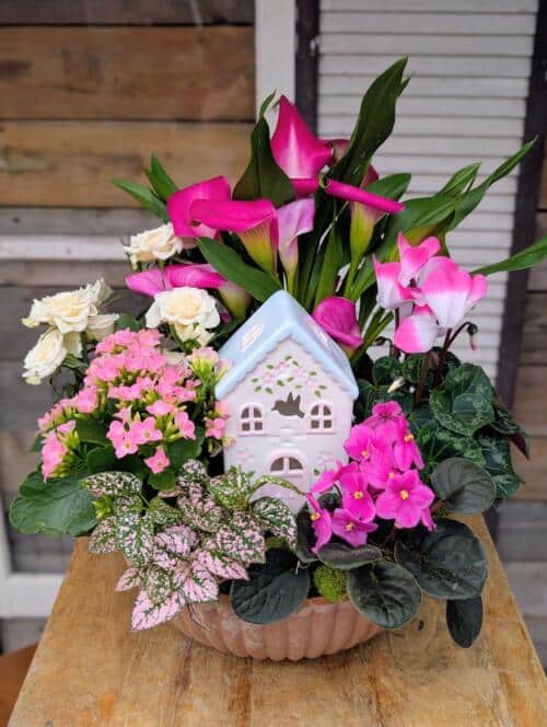 Pink and white floral arrangement with cottage ornament from The Watering Can Flower Market.